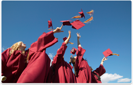 group of graduates throwing caps in the air